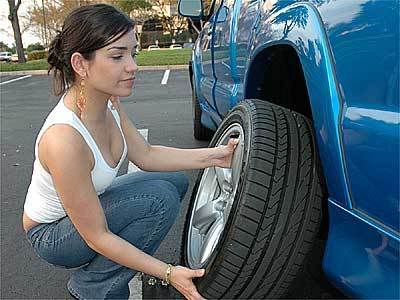 mulher trocando pneu